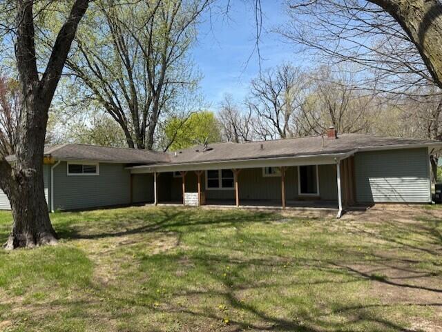 545 W Main St, Centreville, MI 49032 - rear view of house with a chimney and a yard