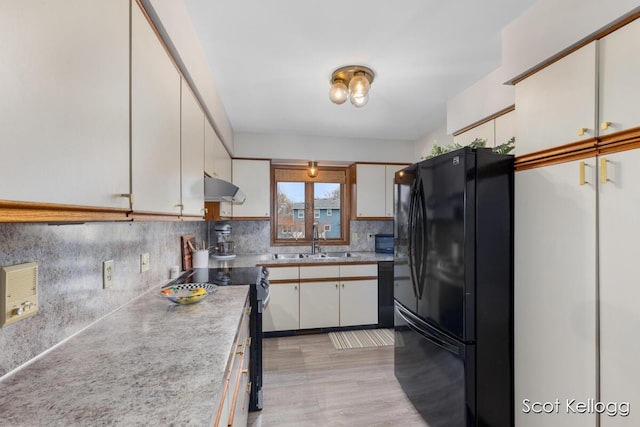 kitchen featuring a sink, under cabinet range hood, black appliances, white cabinetry, and light countertops