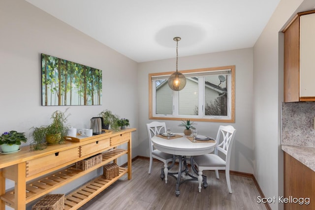 dining area featuring baseboards and wood finished floors