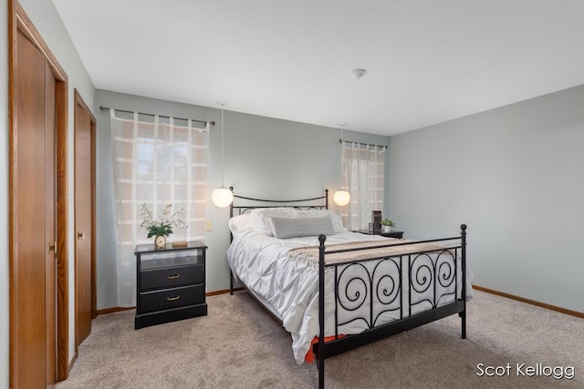 bedroom with baseboards and light carpet