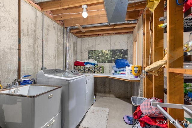 clothes washing area with washing machine and dryer, a sink, and laundry area