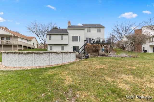 back of property with a wooden deck, a covered pool, a yard, stairs, and a chimney