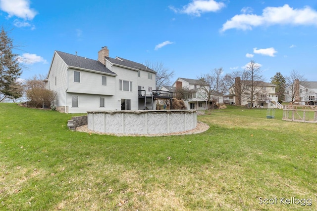 back of property featuring a lawn, stairway, a deck, and a residential view