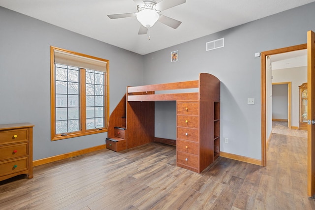 unfurnished bedroom with wood finished floors, visible vents, and baseboards