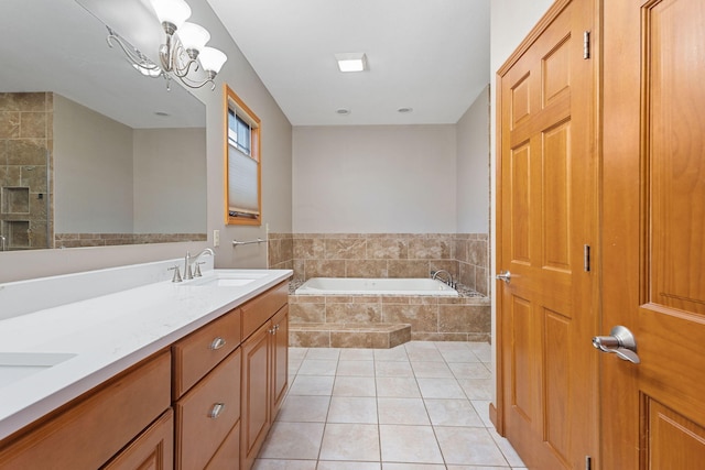 full bath featuring a sink, double vanity, a chandelier, a garden tub, and tile patterned flooring
