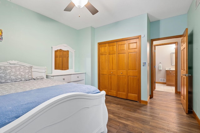 bedroom featuring a closet, ceiling fan, visible vents, baseboards, and dark wood finished floors