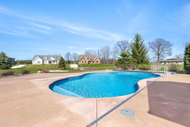 pool with a lawn and a patio area