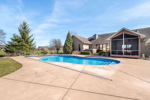 outdoor pool with a patio and a sunroom