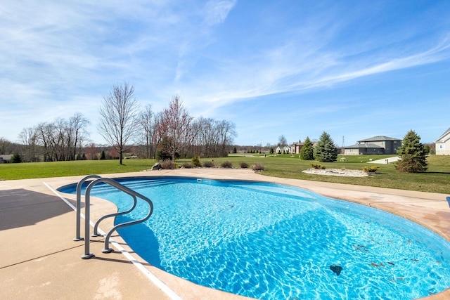 outdoor pool featuring a lawn and a patio