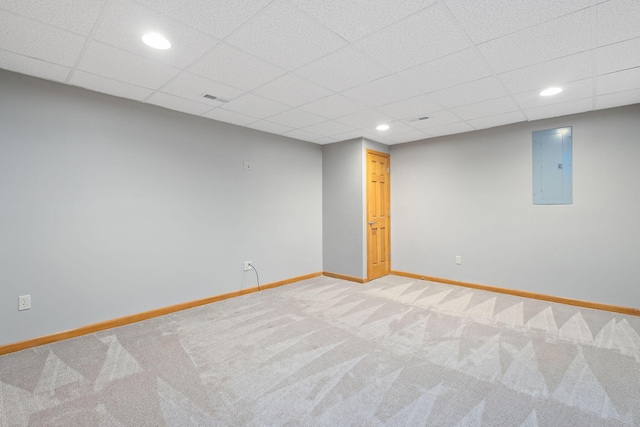 finished below grade area featuring visible vents, baseboards, electric panel, and carpet floors