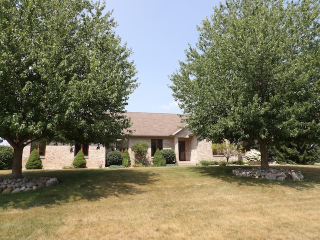 2776 W Hogan Dr, Indiana, IN 46350 - view of property hidden behind natural elements featuring a front yard and brick siding
