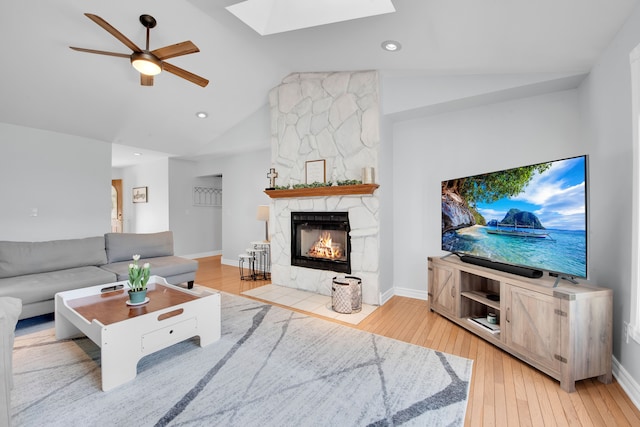73941 Madison St, Armada, MI 48005 - living area with vaulted ceiling with skylight, a fireplace, light wood-style flooring, a ceiling fan, and recessed lighting