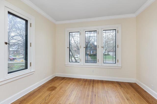 spare room featuring ornamental molding, light wood finished floors, and baseboards