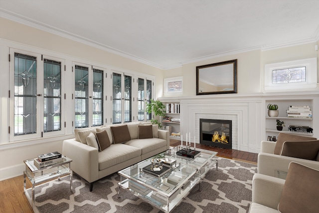 living room with ornamental molding, wood finished floors, a fireplace, and plenty of natural light