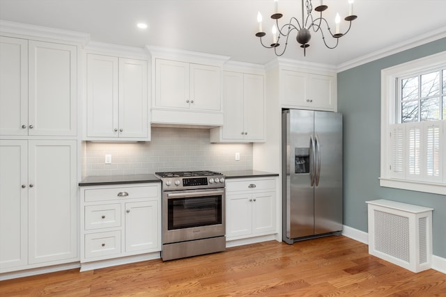 kitchen featuring baseboards, radiator heating unit, stainless steel appliances, and dark countertops