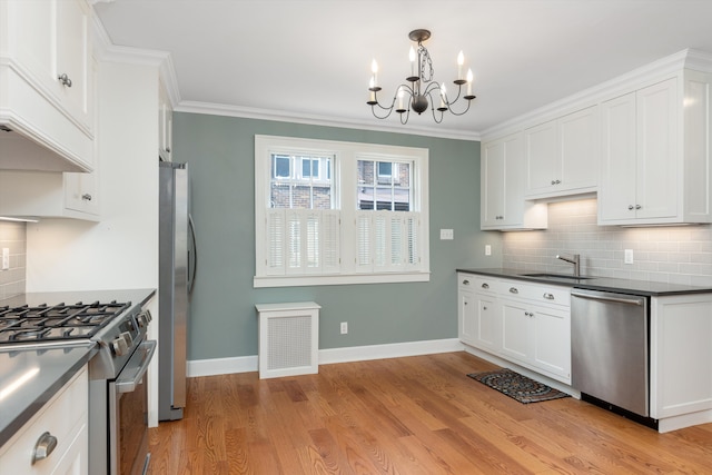 kitchen featuring a sink, visible vents, dark countertops, stainless steel appliances, and a notable chandelier