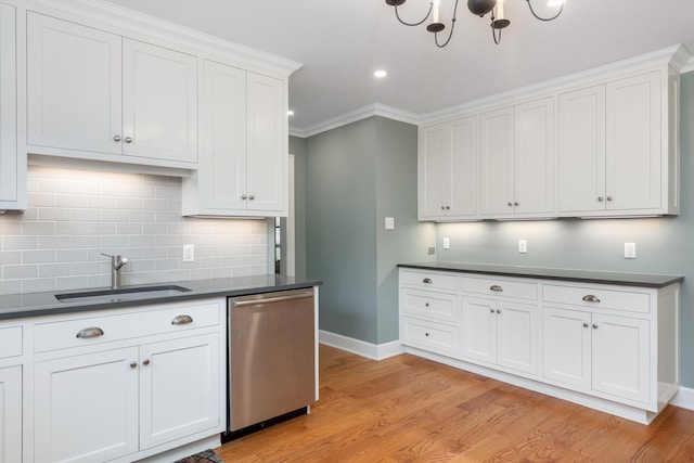 kitchen featuring dark countertops, stainless steel dishwasher, baseboards, and a sink