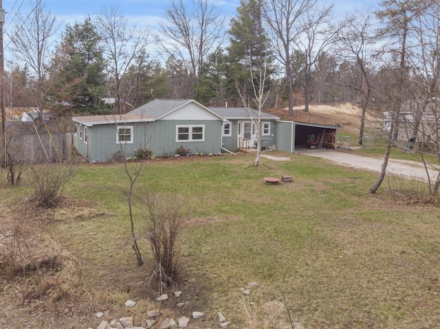 single story home featuring concrete driveway, fence, a front lawn, and an attached carport