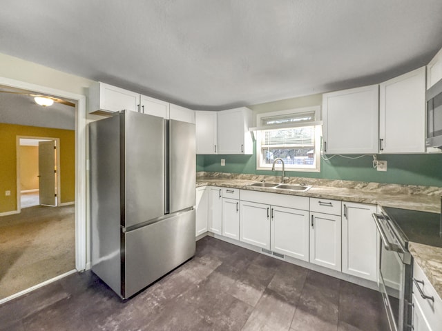 kitchen featuring visible vents, a sink, white cabinetry, and appliances with stainless steel finishes