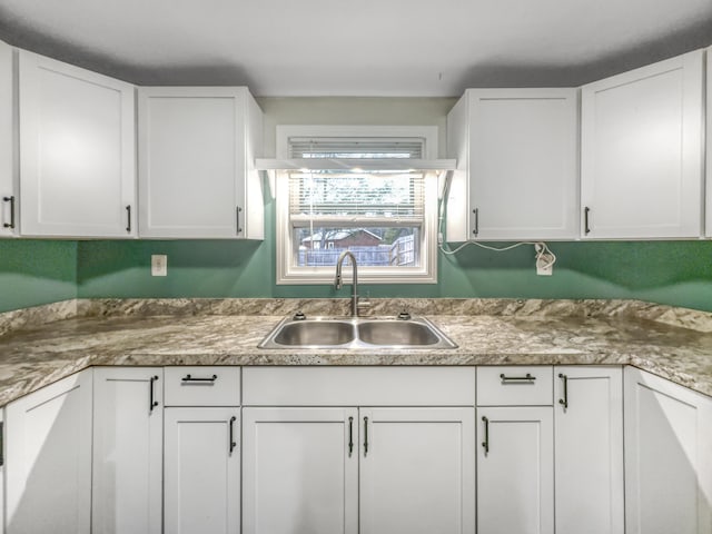 kitchen with a sink and white cabinetry
