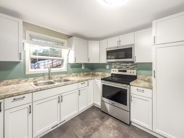 kitchen with visible vents, appliances with stainless steel finishes, a sink, light countertops, and white cabinets