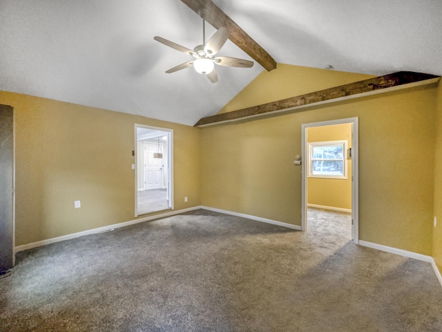 carpeted spare room with baseboards, ceiling fan, and vaulted ceiling with beams