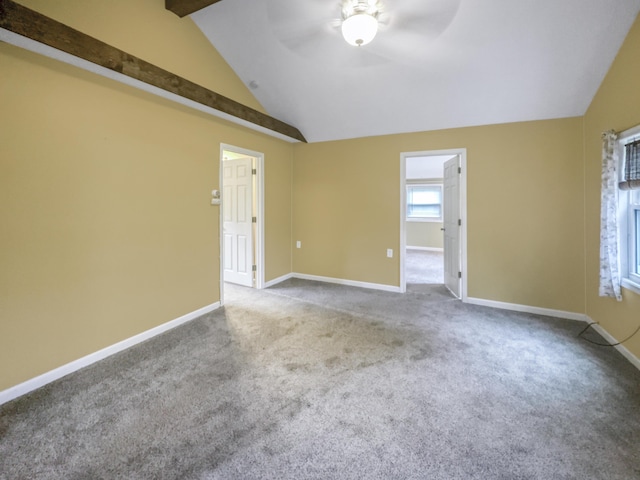 spare room featuring carpet floors, lofted ceiling with beams, baseboards, and ceiling fan