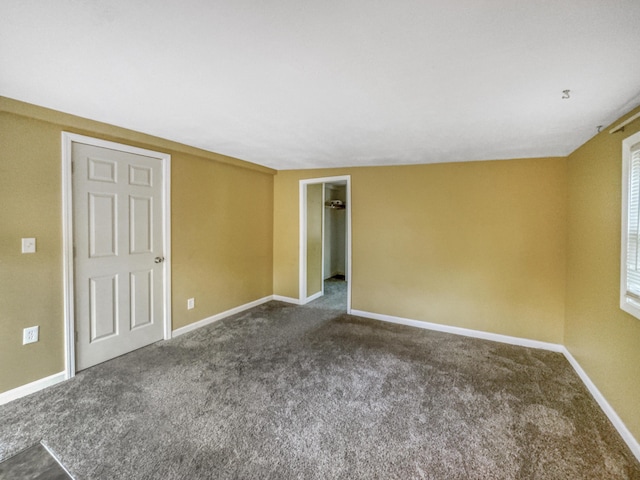 carpeted empty room featuring baseboards