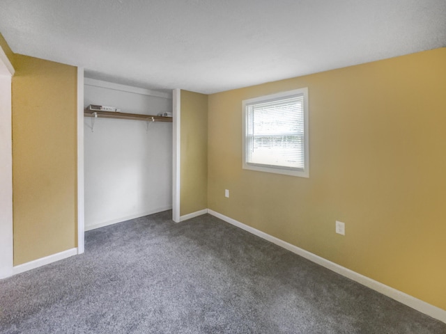 unfurnished bedroom with a closet, carpet flooring, and baseboards