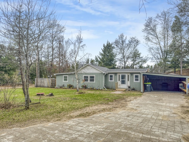 ranch-style house with fence, a carport, decorative driveway, and a front yard