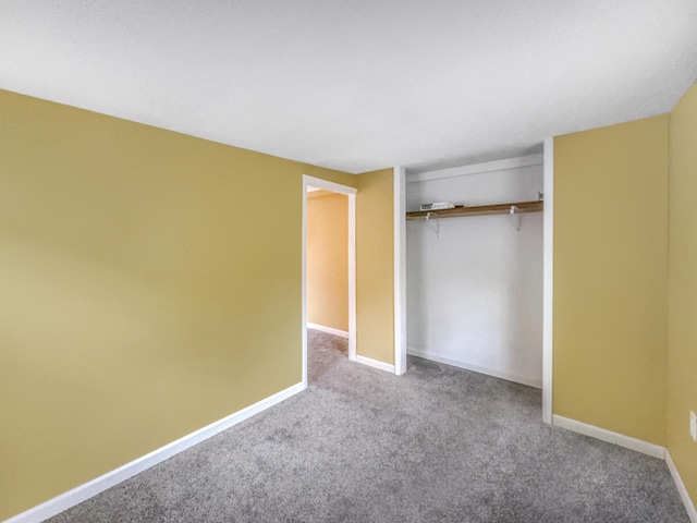 unfurnished bedroom featuring carpet floors, baseboards, and a closet