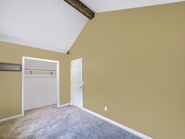 unfurnished bedroom featuring a closet, baseboards, lofted ceiling with beams, and carpet flooring
