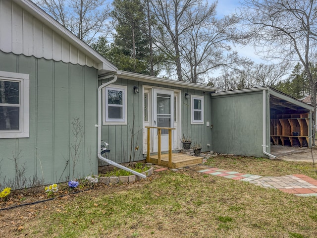 rear view of property with a lawn and board and batten siding