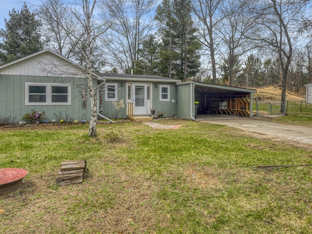 single story home with board and batten siding, driveway, a carport, and a front lawn