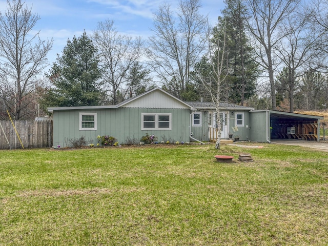 view of front of home featuring a front lawn, fence, board and batten siding, driveway, and a carport