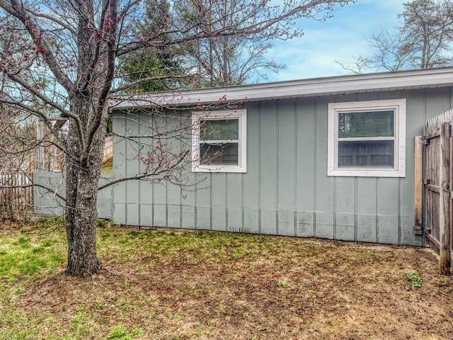 view of side of property featuring board and batten siding and fence