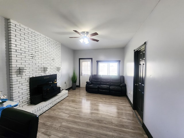 living room with wood finished floors, ceiling fan, and baseboards