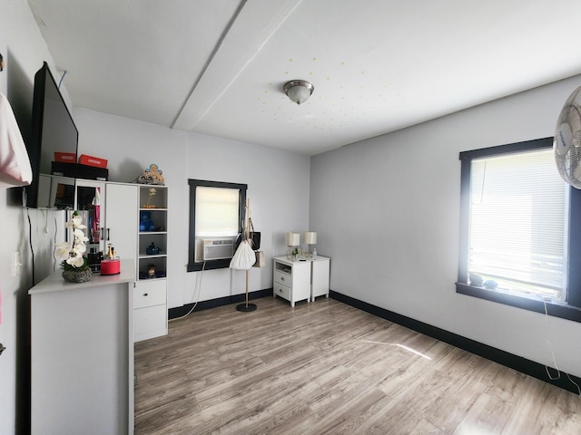 unfurnished office featuring baseboards, wood finished floors, and cooling unit