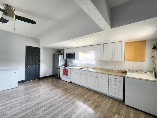 kitchen with washer / clothes dryer, white cabinets, a sink, appliances with stainless steel finishes, and light countertops