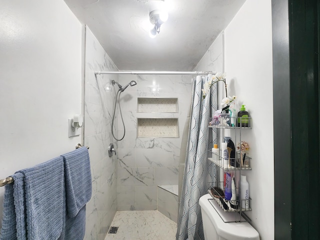bathroom featuring toilet and a stall shower