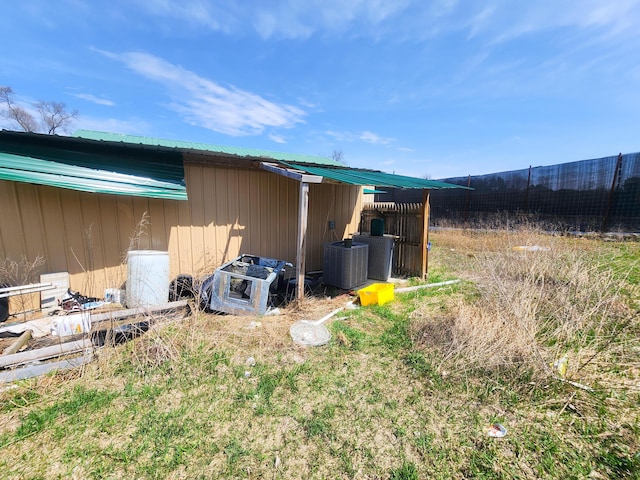 view of outdoor structure featuring fence and central air condition unit