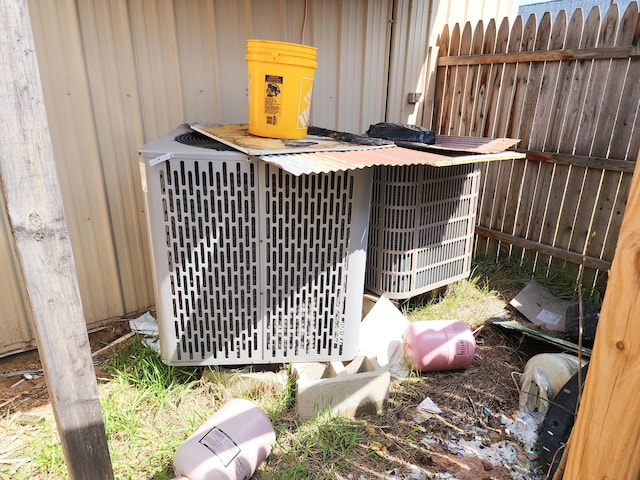 exterior details featuring central AC and fence