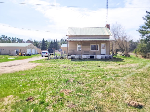 bungalow-style house featuring a porch, metal roof, a garage, driveway, and a front yard