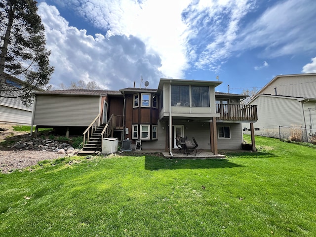 back of house with central AC unit, a patio area, a sunroom, stairway, and a yard