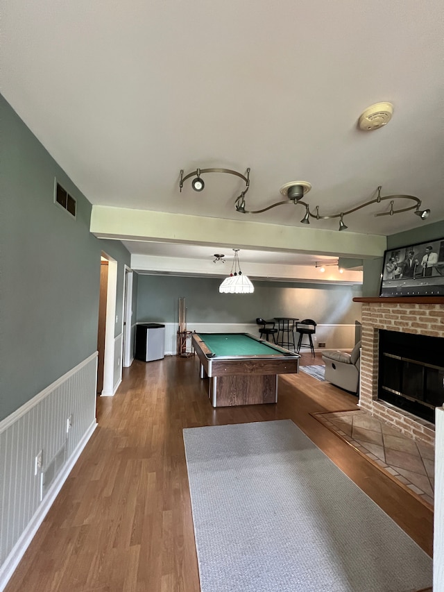 game room featuring pool table, a fireplace, wood finished floors, and visible vents