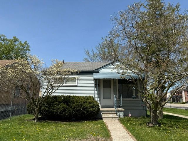 bungalow-style home with fence and a front lawn