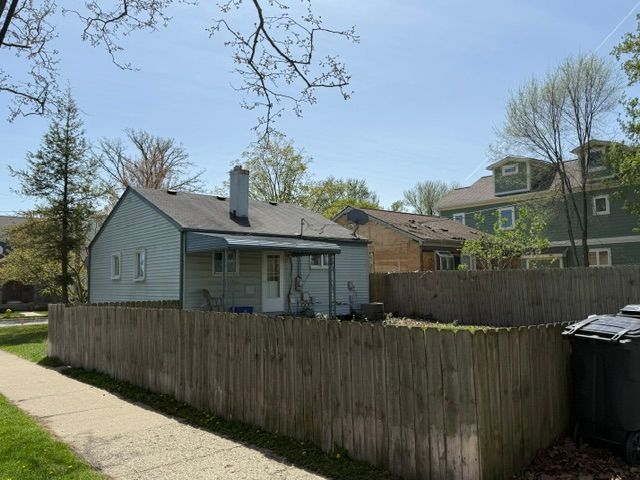 rear view of house with fence and a chimney