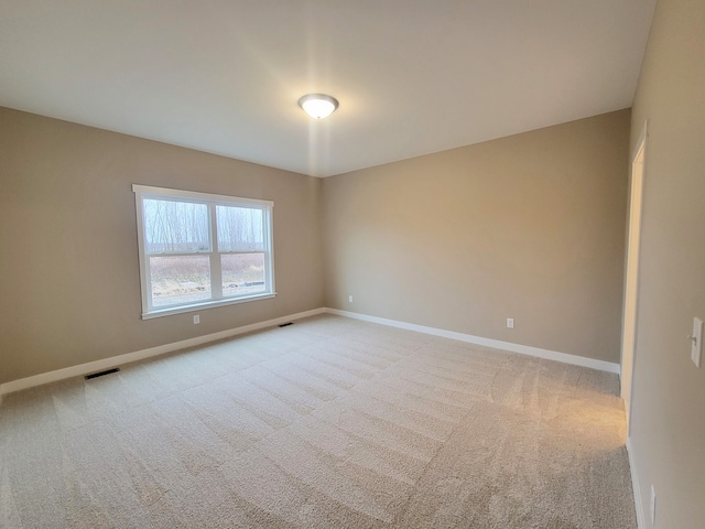 unfurnished room featuring baseboards, visible vents, and carpet flooring