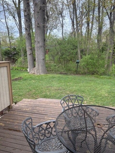 wooden terrace featuring a lawn