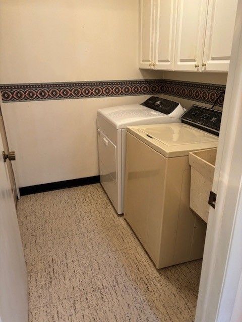 laundry room with a sink, washer and clothes dryer, and cabinet space